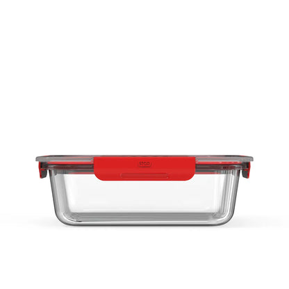 Clear glass food storage container with red lid on a white background
